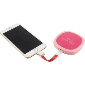 A pink power bank connected to a smartphone via a red charging cable. The power bank has a logo on it.