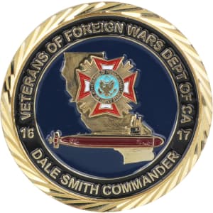 A commemorative gold coin pin featuring a detailed emblem, with blue, gold, and red colours, surrounded by a decorative border.