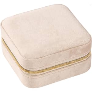 A square velvet jewellery organiser in a soft beige colour with a gold zipper.