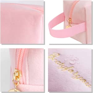 A flannel cosmetic bag in soft pink featuring a zipper and a strap, with a decorative logo in gold.