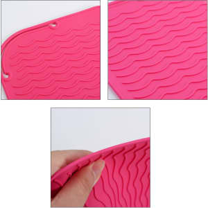 A pink silicone hair straightener pad with wave texture, featuring a hand holding one corner. It has a logo.