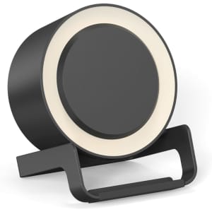 A round black night light speaker with a wireless charging stand. The product features a light ring around the top edge.