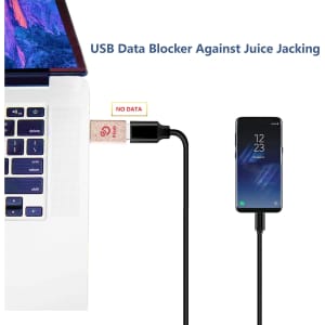 A Wheat Straw USB Data Blocker in beige connects a laptop to a smartphone via a black cable.