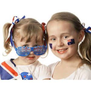 Two children wearing Australian-themed accessories, including flag face tattoos and decorated sunglasses.