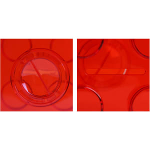 A bright red square block coin bank with a slot on top and a circular opening on the side. It features a logo.