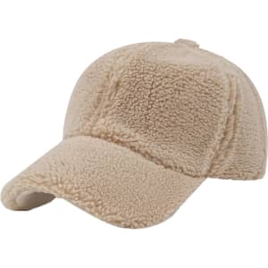A beige lamb fur baseball cap featuring a soft, textured surface and a curved brim. It includes a logo on the front.