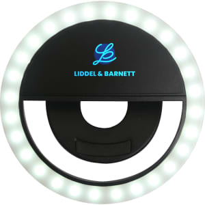 A round, black selfie ring light with white LEDs around the edge and a central opening for attaching to devices.