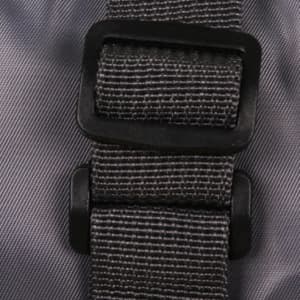 A grey travel compressed bag featuring a sturdy black buckle and strap for secure fastening.