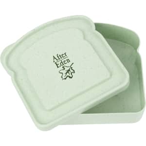 A portable lunch box in light green bamboo fibre, featuring a lid and a logo inside.
