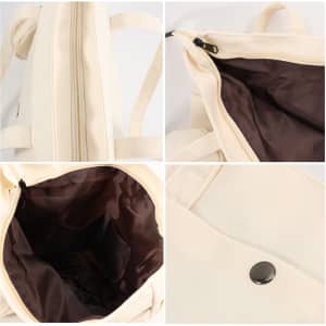 A cream-coloured canvas bag featuring a zip closure and a dark brown interior, with styling details visible.