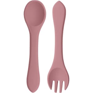 A set of classic silicone kids cutlery in a soft pink colour, including a spoon and a fork. The utensils have a smooth design and are flexible.