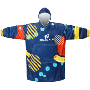 A blue wearable blanket with a colourful abstract design and a large front pocket. It features a hood and has a logo.