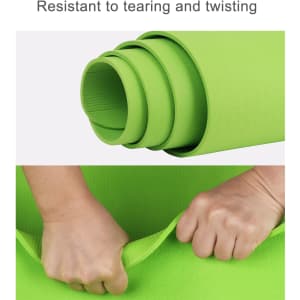 A green TPE yoga mat, rolled tightly with hands gripping the edge, showcasing its flexibility and durability.