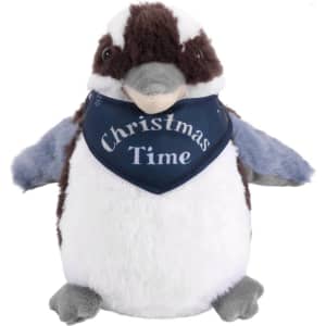A Kookaburra plush toy in brown, white, and grey, wearing a blue bandana with festive text.