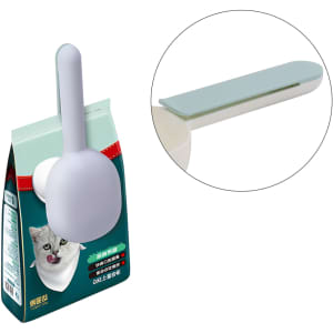 A pet food scoop in light grey attached to a green packaging. The scoop features a flat edge for easy use.