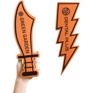 Two orange foam props are held in a hand: a sword shape labelled "GREEN GARDEN" and a lightning bolt labelled "DENTAL PLUS."