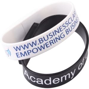 A pair of rectangular silicone wristbands in white and black, featuring various printed text and logos.