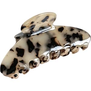 A hair clip in beige and black with a marbled pattern, featuring a large, curved design and multiple grip prongs.