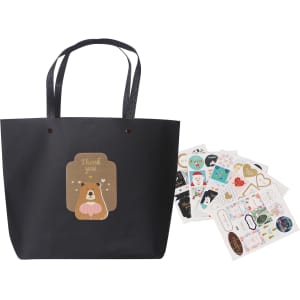 A black boutique paper bag with handles, accompanied by decorative stickers featuring various designs.
