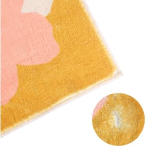 A plush logo mat featuring a vibrant design with pink and yellow colours, highlighting a soft texture and detailed edges.