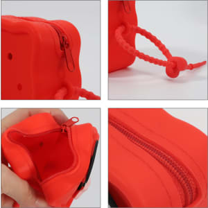 A red square silicone pouch with a zip closure and a corded handle, showcasing its texture and design details.