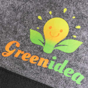 A dark grey felt bag with a logo featuring a smiling light bulb and leafy design in yellow and green.