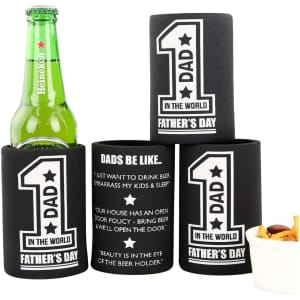 A black stubby holder with base featuring various printed designs, alongside a green drink bottle and a small bowl of snacks.