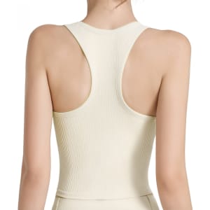 A seamless women's yoga bra tank in cream, featuring wide straps and a racerback design. It has a logo on it.