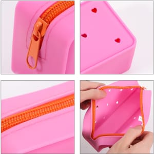 A pink silicone pencil case with orange zipper and heart-shaped holes, featuring an interior compartment.
