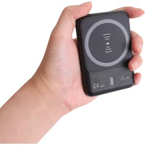 A black 5000mAh eco magnetic power bank held in a hand, featuring a circular design on the surface.