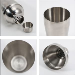 A stainless steel cocktail shaker with a strainer, showcasing its polished interior and exterior. Features a logo.