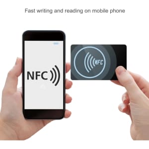 A hand holds a NFC PVC business card beside a smartphone displaying an NFC symbol. The card is black with a logo.