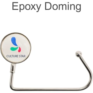 A round silver desk hook with a glossy white circular end featuring a logo with blue and green accents.