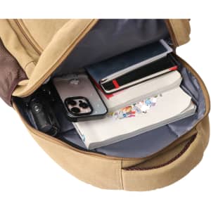 A tan canvas laptop backpack with an open compartment containing notebooks, a phone, and a drink bottle.