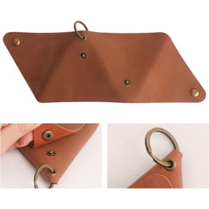 A triangular, tan leather coin holder with brass snaps and a ring for attachment. It has a smooth finish.