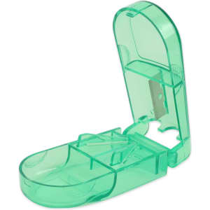 A green pill box with a cutter, featuring a transparent design and a hinged lid. It has a compartment for storing pills.