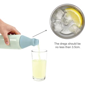 A drink bottle in light blue and white, pouring a beverage into a glass containing ice and lemon.