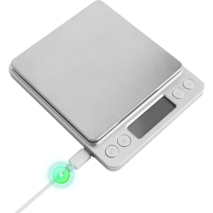 A stainless steel rechargeable kitchen scale with a digital display and charging cable connected.