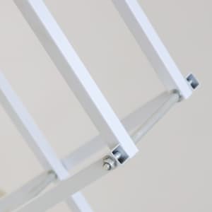 A close-up of a white metal frame, highlighting the joints and support bars of a display stand.
