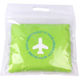 A green compressed travel bag in a transparent packaging with a circular design and a logo.