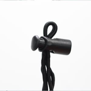 A black adjustable toggle stopper attached to a black cord, designed for securing items.