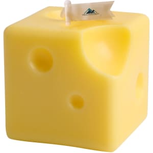 A square yellow candle shaped like cheese, featuring holes and a small flag.