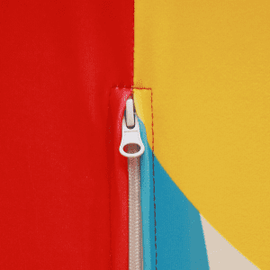 A close-up of a vibrant fabric featuring red, yellow, and blue sections with a zipper detail.