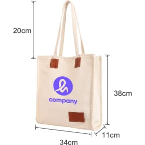 A cream canvas bag with a magnetic snap, leather accents, and a logo on the front, measuring 20cm by 34cm by 38cm.