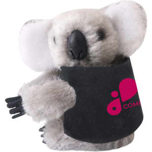 A grey koala plush toy with a black pouch, featuring a logo on the pouch.