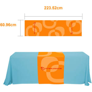 A medium table runner in vibrant orange with a circular design, featuring a logo, set against a blue tablecloth.