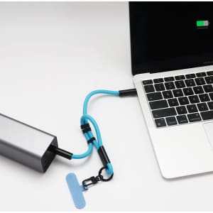 A silver charging power bank with a blue strap connected to a laptop. The image features a logo on the power bank.