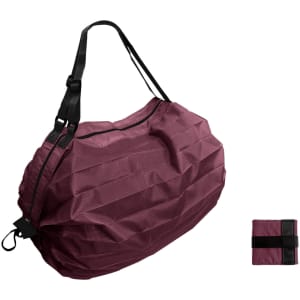 A foldable shopping shoulder bag in a rich burgundy colour, with black straps and a small folded version beside it.