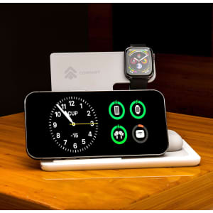 A black 3-in-1 wireless charger featuring a clock display, charging icons, and spaces for a phone and smartwatch.
