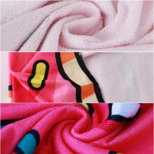 A custom-shaped beach towel featuring a pink background with vibrant patterns in red, yellow, and blue, showcasing its soft texture.